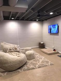 a room that has some couches on the floor and a flat screen tv in it