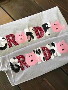 two gray t - shirts with pink and black piggies on them that say crap