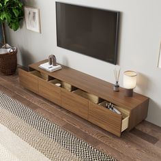 a flat screen tv sitting on top of a wooden entertainment center in a living room