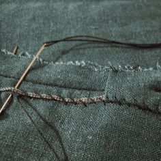 a pair of scissors and some thread on a piece of cloth