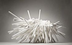 a white sculpture made out of sticks on top of a table