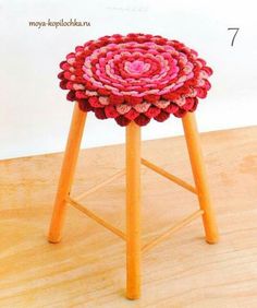 a wooden stool with a crocheted flower on it