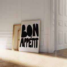 a black and white poster sitting on top of a hard wood floor next to an open door