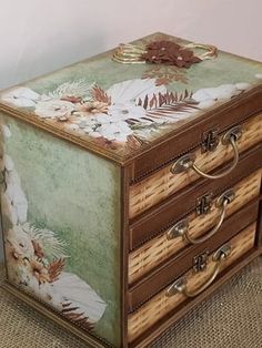 an ornate wooden box with flowers and leaves painted on the lid, sitting on a carpeted floor