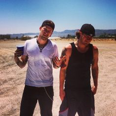 two men standing next to each other in the desert