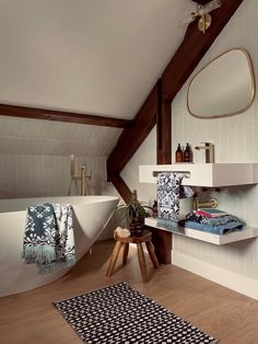 a bath room with a rug a sink and a mirror on the wall in it