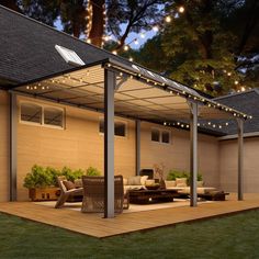 a covered patio with furniture and string lights on the roof is lit up at night