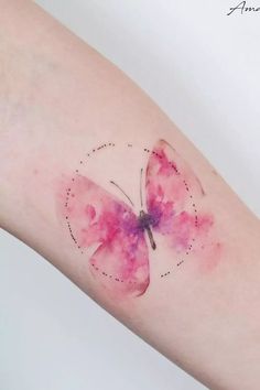 a pink butterfly tattoo on the left forearm and right arm, with dots in it's wings