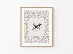 a framed print of a dog running in the snow with leaves on it's border