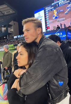 a man and woman standing next to each other at a baseball game