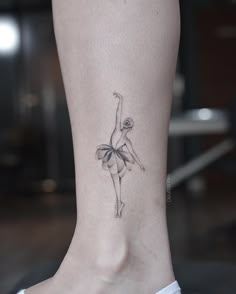 a woman's foot with a ballerina tattoo on her left ankle and the bottom part of her leg