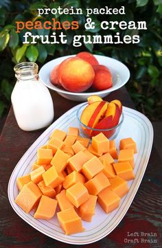 peaches and cream fruit gummies are on a plate next to a bowl of yogurt