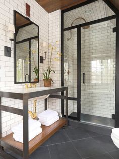 a bathroom with a sink, mirror and towel rack in the middle of the room