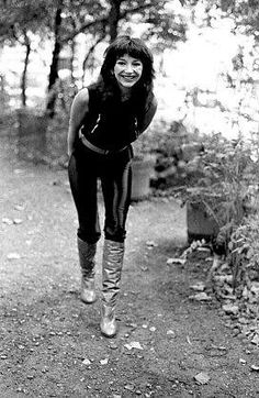 black and white photograph of a woman walking in the woods