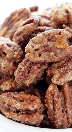 a white plate filled with pecans on top of a table