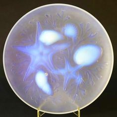 a glass plate with three starfishs in the center on a stand against a black background