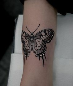 a black and white butterfly tattoo on the right leg, it looks like an insect