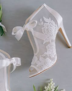 wedding shoes and boutonnieres with flowers on the table next to each other