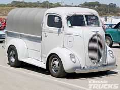 an old white truck parked in a parking lot