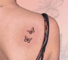 two butterflies on the back of a woman's shoulder