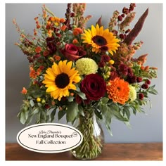 a vase filled with sunflowers, roses and other flowers on top of a table