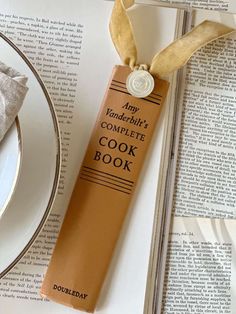 an open book on top of a table next to a plate