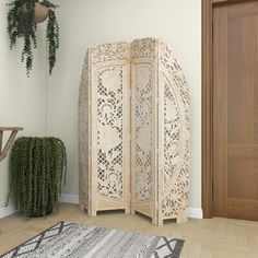 a room divider sitting on top of a hard wood floor next to a potted plant