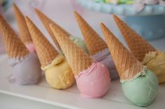 five ice cream cones are lined up on a table