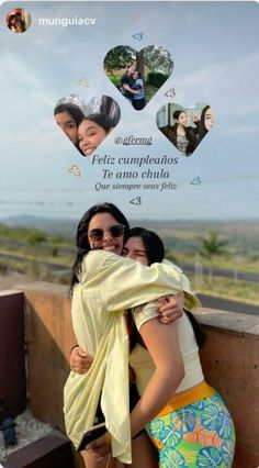 two women hugging each other on the side of a wall with an advertisement in the background