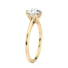 a yellow gold engagement ring with a single diamond in the center, on a white background