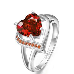 a heart shaped ring with orange and white stones on the sides, set in silver