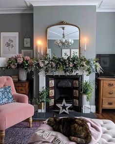 a living room with a cat laying on a rug in front of a fire place