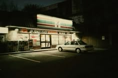 a car parked in front of a store at night