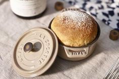 a table topped with a pastry covered in powdered sugar next to a bottle of wine