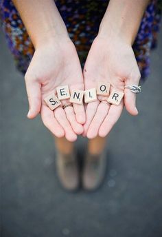 someone is holding their hands together with the word senior spelled out in scrabble letters