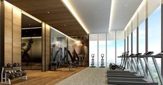 a gym with treadmills, exercise machines and large windows overlooking the cityscape