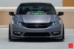 the front end of a gray car with hondas finest housewars sticker on it