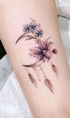 a woman's leg with a flower tattoo on it and an arrow in the middle