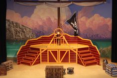 an image of a stage setting for a musical show with pirate ship and flag on it