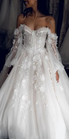 a woman in a white wedding dress with flowers on it