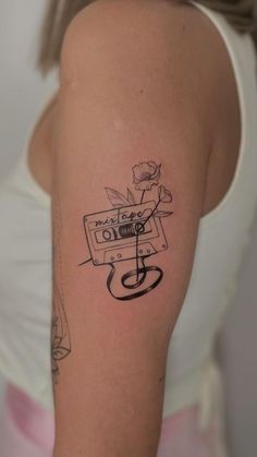 a woman's arm with a tattoo on it that has a tape recorder in the middle