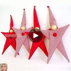 three red and white stars hanging on the wall with a woman smiling in front of them