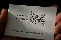 someone is holding up a business card with the words moontree letterpress on it