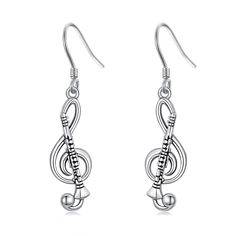 earrings with musical notes and trebles hanging from the ear hooks on a white background