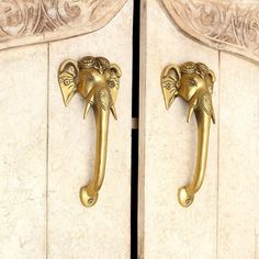 an elephant head door handle is shown on the side of a white marble cabinet with gold accents