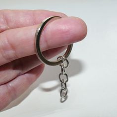 a person holding onto a metal ring with a chain attached to it's end