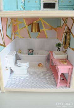 a doll house bathroom with sink, toilet and bathtub painted in pastel colors