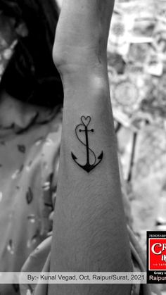 a small anchor tattoo on the left wrist and an i love you sign in the middle