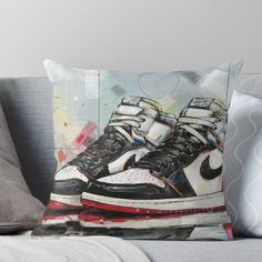 a painting of a pair of sneakers on top of a couch throw pillow with the image of an air jordan shoe painted on it