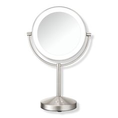 a round mirror sitting on top of a metal stand